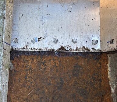 Corroded steel beam at the end of the gutter run